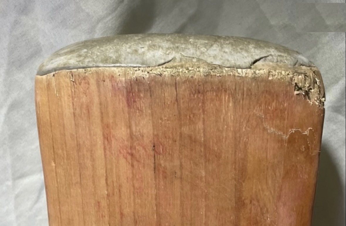Cricket bat before repair, showing edge damage